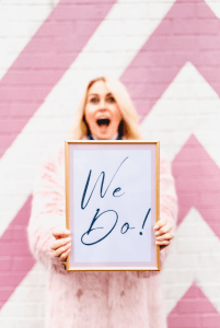 Katie Isles humanist wedding celebrant holding a WE DO sign